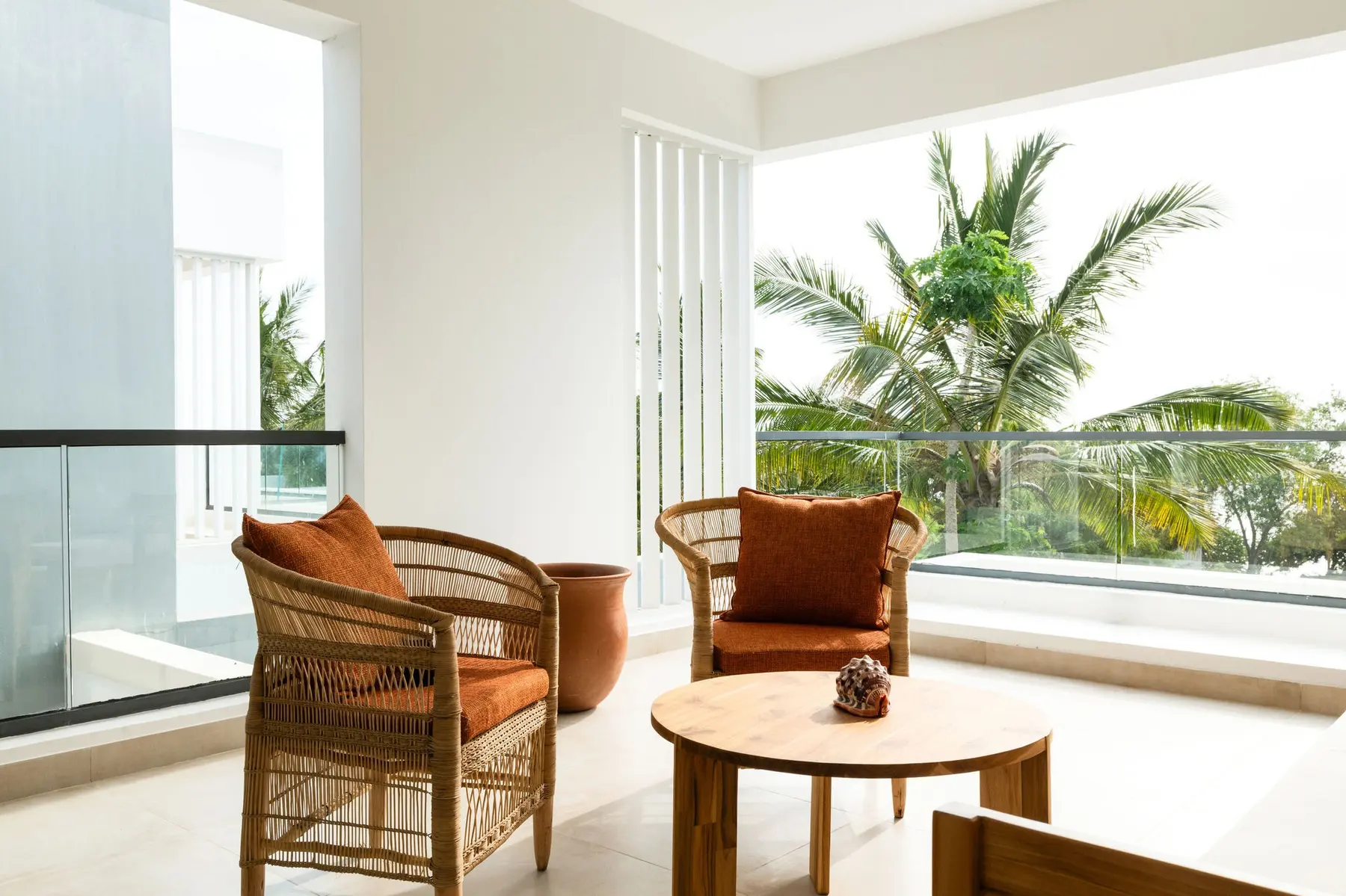 Balcony with rattan chairs and a view of the palms